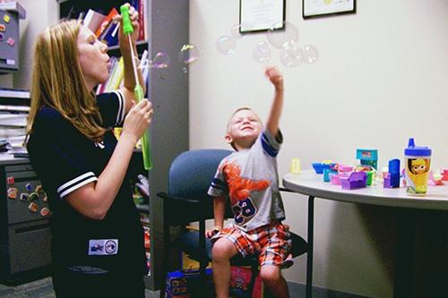 一个治疗师和一个孩子玩泡泡作为治疗的一部分